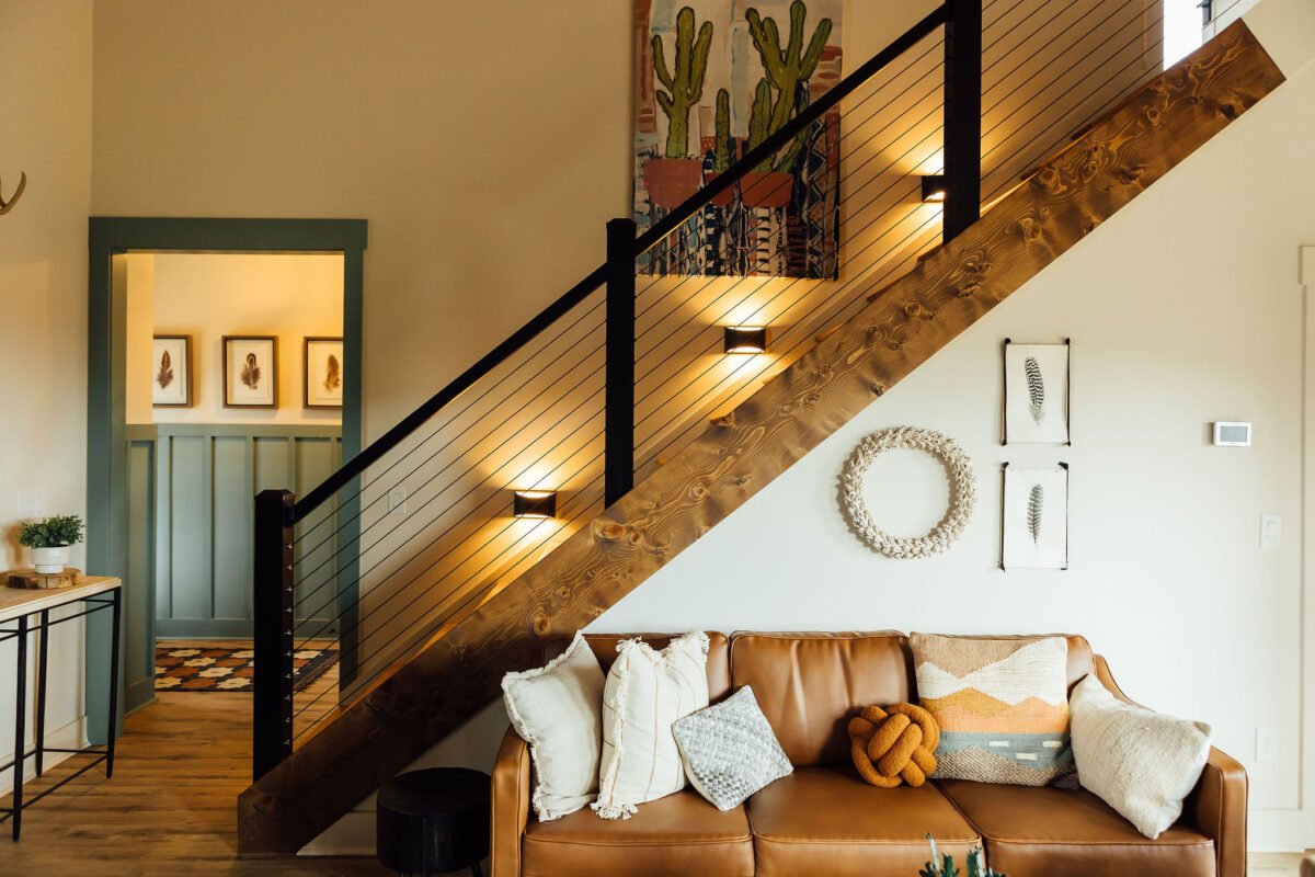 Warm lodge interior with staircase, sofa, and decor where wedding families gather at KC Bison Ranch in Dahlonega
