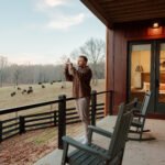 Couple standing on a lodge deck at KC Bison Ranch watching a bison herd graze in the North Georgia mountains
